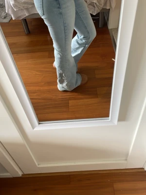 Ljusblå bootcut jeans - Säljer ett par ljusblå bootcut jeans med mid waist och klassiska fickor bak. Jeansen har en snygg utsvängd passform och är perfekta för dig som gillar classy och elegant klädsel. Tillverkade i mjukt denimtyg som sitter skönt hela dagen.