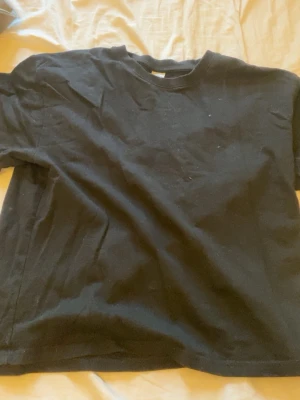 Svart basic t-shirt i bomull - Enkel svart t-shirt i mjuk bomull med rund hals och korta ärmar. Perfekt till jeans eller shorts för en clean och avslappnad look!
