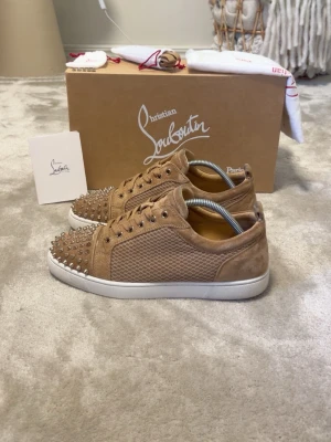 Beige Christian Louboutin sneakers - Storlek: 42-43 Skick: 9,3/10 – Nypris: ca 10 300 kr Allting originalt ingår Extra nitar ingår (5st) 100% autentiska Kom privat vid frågor & köp.