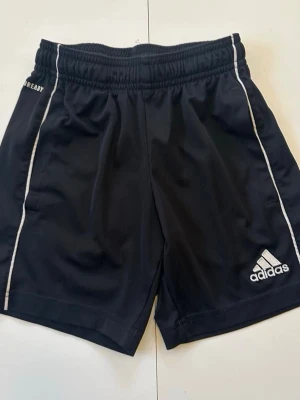 Svarta adidasshorts till barn strl 116-122  - Storlekslappen är avklippt men passar 116-122. Smal tight midja  Shorts Kortbyxor  Barn Adidas Byxor
