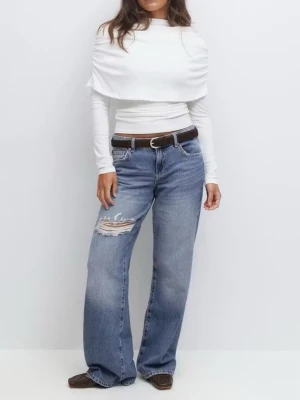 Wide Jeans - Säljer ett par klassiska blåa vida jeans från Gina Tricot med slitning och hål på ena låret. Jeansen har fem fickor fram och bak.  Perfekta för en avslappnad och trendig look.