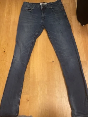 Blå slim fit jeans från denim project - Snygga blå slim fit jeans med klassisk femficksdesign och lätt slitna detaljer framtill. Jeansen har normal midja och smala ben, perfekta för en trendig och avslappnad look. Tillverkade i stretchigt denimtyg för extra komfort. Storlek xs/s