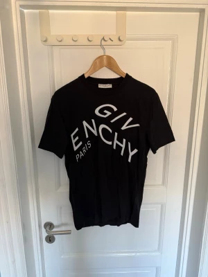 Svart Givenchy t-shirt med tryck - Svart t-shirt från Givenchy med stort vitt logotryck över bröstet. Klassisk rund hals och korta ärmar. Tillverkad i 100% bomull. Vid fler frågor eller intresse för fler bilder är det bara att höra av sig. 