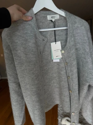 Ljusgrå kofta från Gina Tricot - Mysig ljusgrå kofta från Gina Tricot i ullblandning. Koftan har rund halsringning, långa ärmar och pärlemorknappar framtill. Super snygg och bekväm!🩷 säljer för jag inte fick användning till den💋 skriv i dm för frågor 