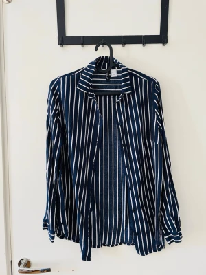 Blåvit randig skjorta  - Snygg blå skjorta med vita vertikala ränder från H&M. Passar stl. S