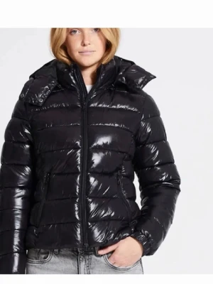 Svart glansig pufferjacka med huva - Säljer en svart glansig pufferjacka med avtagbar huva och dragkedja framtill. Jackan har quiltad design, två fickor med dragkedja och hög krage. Perfekt för kalla dagar och riktigt snygg till jeans.