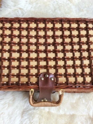 Picknickkorg med blå plastbestick nyskick - Säljer en klassisk picknickkorg i flätad rotting med handtag och läderdetaljer. Insidan har blåvitrutigt tyg och innehåller blå plastbestick och tallrikar. Perfekt för utflykter och picknick med vänner.