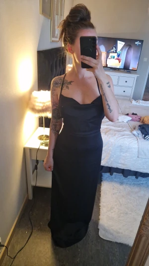 Svart långklänning med öppen rygg, bikbok - Riktigt snygg klänning ,dock alldeles för lång för mig , blivit att den legat nerpackad,istället för att få den uppsydd💥 faller fint över bysten,öppen rygg med knytning, även dragkedja.  Och skönt material🌌👌 Oanvänd
