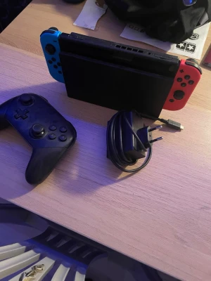 Nintendo Switch med neonröda och blå Joy-Cons - Säljer Nintendo switch eftersom jag inte använder den längre den är helt fungerande förutom den blåa kontrollen alla knappar fungerar men joysticken går inte att pressa ner. Du får med laddare och kontroll för en billig peng.