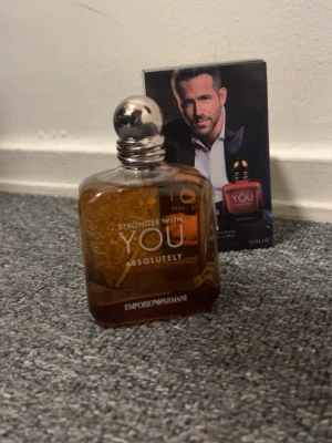 Emporio Armani Stronger With You - Emporio Armani Stronger With You Absolutely är en herrparfym i en elegant, fyrkantig glasflaska med rundad silverfärgad kork. Flaskan har en varm bärnstensfärgad ton och stilren text i vitt och guld. Doften är modern och maskulin, perfekt för dig som vill sticka ut.   100 ML 