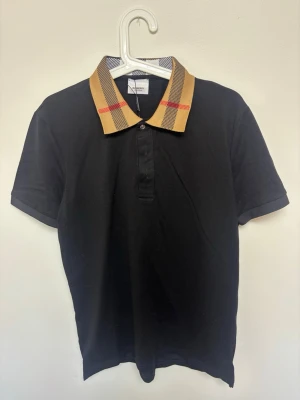 Svart Burberry piké slimfit  - Svart burberry piké i slimfit modell, perfekt nu till sommaren | Storlek Medium | Fraktar samma dag om köp sker innan 22:00