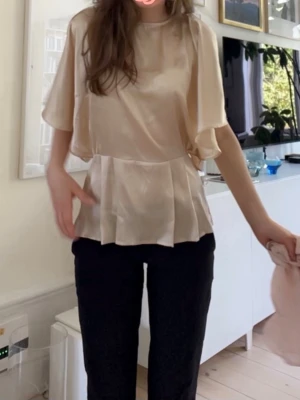 Champagnefärgad satinblus - Elegant blus i skimrande champagnefärgad satin från ASOS. Perfekt för sommaren, skriv vid frågor.