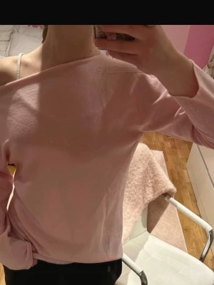 Ljusrosa off shoulder tröja - Säljer en ljusrosa off shoulder tröja med lång ärm och avslappnad passform. Tröjan har en enkel design utan mönster eller detaljer och är tillverkad i ett mjukt, tunt material som känns skönt mot huden. Perfekt för dig som gillar en stilren och trendig look. Står XL men är mer som S
