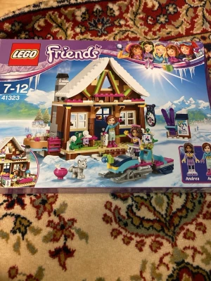 LEGO Friends Vinterstuga 41323 - Säljer ett LEGO Friends set, Vinterstuga 41323. Innehåller en mysig fjällstuga med snötäckt tak, snöskoter, skidutrustning och figurerna Andrea, Olivia och Mia. Perfekt för dig som gillar vinteräventyr och att bygga detaljerade miljöer i plast.