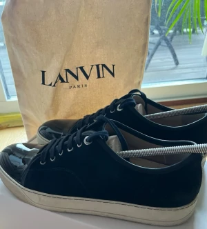 Lanvin DBB1 - Dessa Lanvin DBB1 Patent Cap Toe Sneaker Navy är sparsamt använda och i väldigt fint skick. De är trendiga och väldig stilrena. Dustbag tillkommer men inte original förpackningen.