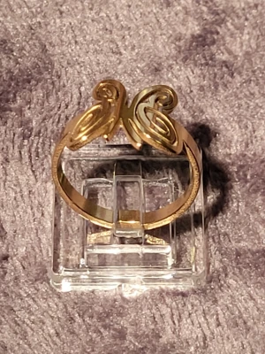 Guldfärgad ring med fjärils mönster - Unik guldfärgad ring med ett snirkligt fjärils mönster framtill som ger en cool och konstnärlig vibe. Ringen har en bredare ringbas och är tillverkad i metall med blank finish. Perfekt för dig som gillar statement-smycken och vill sticka ut.