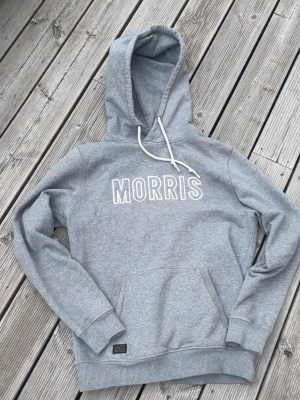 Morris hoddie - Säljer en grå Morris hoddie i storlek M. Den ä i bra sick och den enda defekten är ett litet håll längst ner i armen som knappt märks av. Därför är det ett lägre pris. Om man vill ha fler bilder eller har frågor är det bara att höra av sig🙌