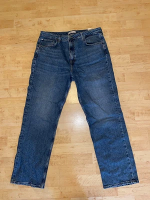 Blå raka jeans  - Klassiska blå jeans med rak passform och fem fickor. Jeansen har en tidlös look med normal midja och dragkedjegylf. Tillverkade i slitstark denim som passar perfekt till en avslappnad stil.