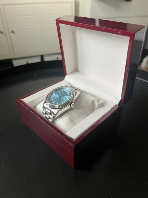 Seiko mod daydate - Snygg Seiko mod daydate med ljusblå urtavla, ribbad bezel och presidential länkarmband. Den är i riktigt bra skick, inte en enda repa på hela klockan. Klockan är mekanisk så du behöver aldrig byta något batteri, glasad baksida. Skriv om du har frågor!