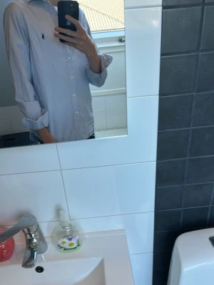 Blårandig skjorta från Ralph Lauren - Säljer en vit ralph lauren skjorta med blå randigt mönster. Den är näst intill helt ny, använd 2 gånger och perfekt till midsommar. Däremot råkade jag spilla på den därav priset(dock syns det inte så länge man inte kollar jätte noga). Köpte den för 1999kr storlek S och priset kan diskuteras vid snabb affär. Tveka inte att höra av dig vid minsta fråga🙌🙌
