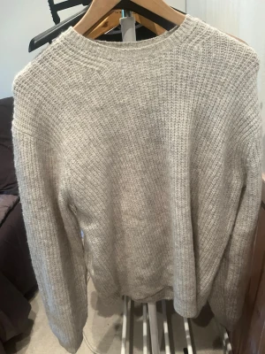 Beige stickad tröja från Vailent - Säljer en beige stickad tröja från Vailent i storlek S. Tröjan har en klassisk rund halsringning och är gjord i ett mjukt, grovstickat material. Perfekt för lager på lager och enkel att matcha med olika outfits.