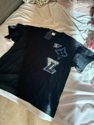 Svart Tshirt - Svart tshirt med blå/vit detaljer