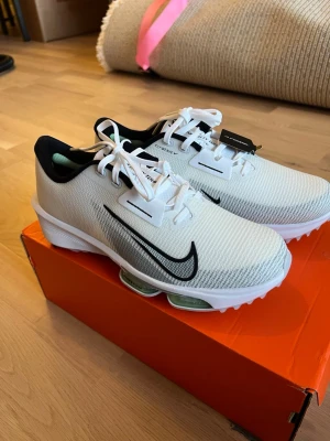 Vita Nike Infinity Tour 2, golfskor (oanvända) - Säljer dessa helt oanvända Vita Nike Infinity Tour 2, golfskor. Storleken är 40,5. Nypris ca 1999 kr, säljer för 950 kr. Kan postas, köparen står då för frakten. Skriv för fler bilder eller frågor.