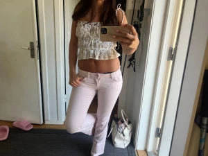 Rosa jeans  - Säljer ett par ljusrosa bootcut jeans med låg midja och klassisk femficksdesign. Jeansen har utsvängda ben och är perfekta för en trendig och avslappnad look. Materialet känns mjukt och stretchigt, vilket gör dem bekväma att bära hela dagen.