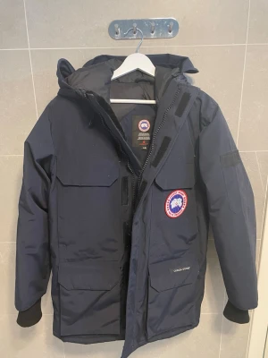 Mörkblå dunjacka Canada Goose - Farsan köpte mig den men gillade inte riktigt den.   Därför har jag aldrig haft på mig den och den är helt ny. Den är riktigt varm och perfekt för vintern. Tyvärr köpte vi den för 14000 men pga av att de finns så många falska måste man sälja den för en del billigare… den är large men passar mig utmärkt som är medium