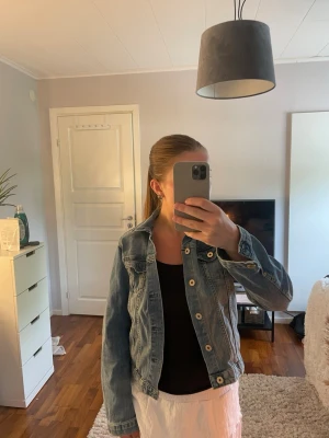 Jeansjacka - Snygg blå jeansjacka i klassisk modell med knappar framtill och två bröstfickor. Jackan har en rak passform och är perfekt att slänga över en topp eller klänning. Tidlös design som funkar till många olika stilar. Använd fåtalet gånger och inget tecken på användning eller slitage förekommer