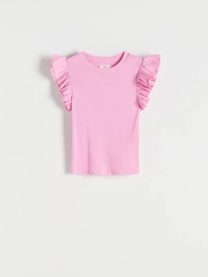 Zara rosa volangtopp - Supersöt rosa topp med volangdetaljer på axlarna och ribbad struktur från Zara. Rund halsringning och ärmlös design som ger en trendig och ungdomlig look. Perfekt att styla med jeans eller kjol för en färgglad outfit.