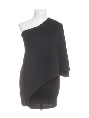 Svart oneshoulder kortklänning - Stilren svart kortklänning med oneshoulder-design och asymmetrisk skärning. Klänningen har en lösare passform upptill och smalnar av nedtill, vilket ger en modern och trendig look. Perfekt för dig som gillar minimalistisk stil.