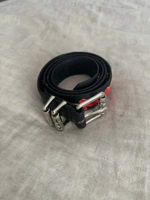 Roller belt - Coolt svart skärp från Chrome Hearts med unika silverdetaljer på spännet och hällorna. Skärpet har en klassisk form och är tillverkat i skinn, perfekt för att lyfta vilken outfit som helst. 105 -110 cm
