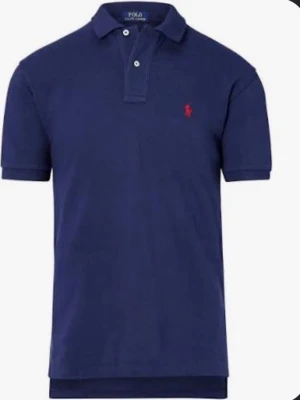 Marinblå piké från Polo Ralph Lauren - Klassisk marinblå pikétröja från Polo Ralph Lauren med korta ärmar och röd broderad logga på bröstet. Tillverkad i mjuk bomull och har knappar vid kragen. Perfekt för en stilren och avslappnad look.