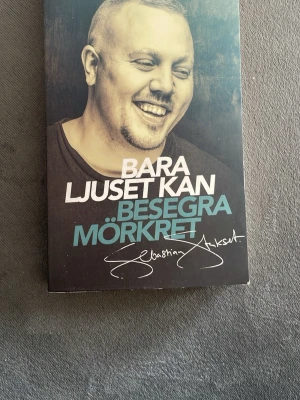 Bara ljuset kan besegra mörkret - En gripande bok om kampen mellan ljus och mörker, skriven av Sebastian Stakset. Omslaget är mörkt med vit och blå text samt ett porträtt. Boken berättar om författarens resa från kriminalitet till hopp och tro. Perfekt för dig som gillar starka livsöden och självbiografiska berättelser.