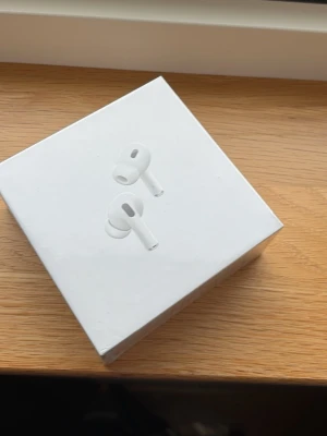 AirPods Pro 2 - Säljer ett par Apple AirPods Pro (2nd generation) i vitt. Trådlösa in-ear hörlurar med silikontoppar och aktiv brusreducering. Kommer i originalförpackning. Perfekta för musik, poddar och samtal. Stilren design och smidig laddning via USB-C.
