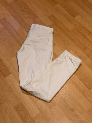 Chinos fràn GAP - Slim fit, storlek 32/34  - Säljer ett par fräscha chinos frän GAP i en fin ljus färg (off-white/beige). Modellen är "Slim" och de sitter väldigt snyggt. Perfekta basplagg till vären och sommaren. Märke: GAP (GAP FOR GOOD) Storlek: 32/34 Passform: Slim fit Skick: Mycket fint skick, sparsamt använda. Hör av dig om du vill ha mätt eller har nagra frägor!