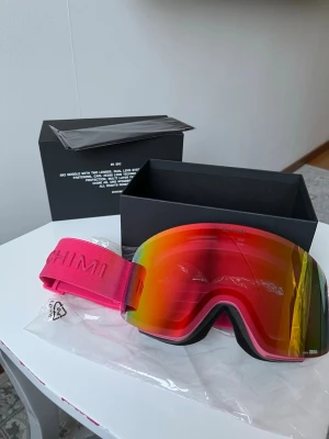 Chimi skidglasögon - Säljer ett par Chimi Ski Goggles modell 01 i mycket fint skick. Kommer med originalbox, fodral och två utbytbara linser (en spegel/reflekterande och en ljusare). Perfekta för skidåkning/snowboard med bra sikt i olika ljusförhållanden. Stilren design och hög kvalitet med Zeiss-linser.