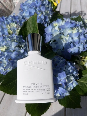 Creed Silver Mountain Water 50ml/ Full  - Lyxig parfym från Creed i doften Silver Mountain Water. Flaskan är vit med silverfärgat lock och har en elegant, stilren design. Kommer i originalförpackning med exklusiva detaljer i guld och silver. Perfekt för dig som gillar fräscha och unika dofter. Kvitto, Box, finns kvar! Ordinarie pris 2599kr mitt pris 1999kr/ Flaskan har 48 ml kvar!