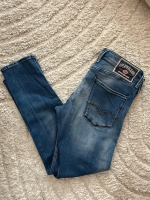 Replay Anbass jeans  - Snygga blåa replay Anbass jeans. Midja 43cm, längd 99cm. Längd storleken saknas, men jag skulle bedöma till L32 - emn utgå efter mått. Obs jeansen har en liten fläck baktill på låret. Samt vänstra framfickan är det ett hål i. JAG SKICKAR EJ FLER BILDER NÄR JAG BÄR JEANSEN! för bättre inblick i passformen rekommenderar jag att googla på modellnamnet. För storleksguide kolla måtten noggrant då jeansen alltid kan vara uppsydda heller krympta och jag ej tar emot returer :) 1,100