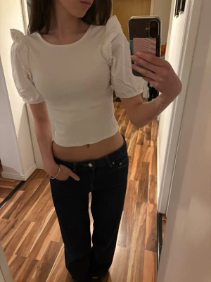 Puffärmad topp - Säljer denna supersöta vita puffärmade toppen, helt perfekt nu till sommaren. Den är i barnstorlek 134 men jag brukar ha XS för att jämföra. I jättebra skick, inga tecken på slitage eller användning!!💕