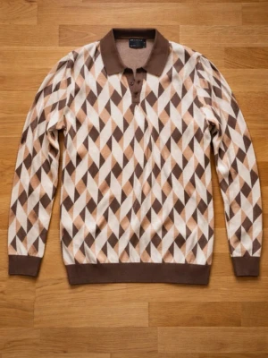 Brunmönstrad tröja från ASOS DESIGN - Säljer en långärmad tröja från ASOS DESIGN med brunt, beige och vitt geometriskt mönster. Tröjan har krage, knappar vid halsen och ribbade muddar. Perfekt för dig som gillar retrovibbar och unik stil.