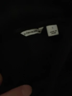 Svart hoodie från Björn Borg - Svart hoodie från Björn Borg med stor logga och texten 'SINCE 1956' på bröstet. Klassisk modell med huva och dragsko. Perfekt för en chill och sportig look. Tillverkad i mjukt material som känns skönt mot huden.