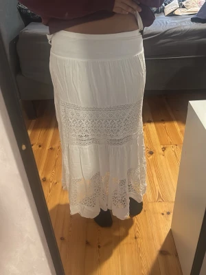 Vit långkjol med spetsdetaljer - Säljer en vit långkjol från F.X Pronto Moda med bred midjeresår och vackra spetsdetaljer. Det finns ingen storlek på den utan den är onesize Kjolen är tillverkad i mjuk viskos.🌸