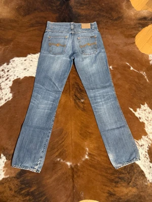 Nudie LowSlimJim DarkUsed - Tjena! Säljer dessa riktigt snygga nudie i modellen LowSlimJim, byxorna är ifrån tidigt 2000tal, finns någon lagning och lite tunnare material på något ställe, W31/L34, hör av dig vid funderingar!🙌