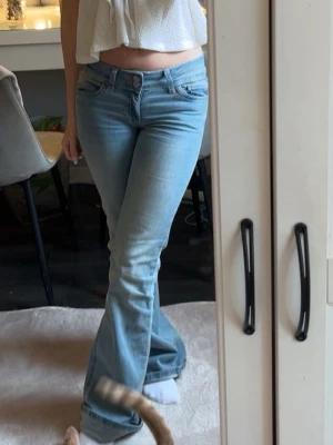 Ljusblå bootcut jeans - Säljer ett par ljusblå bootcut jeans med rosa sömmar på bakfickorna från Nelly, i xs. De är i fint skick, använda fåtal gånger. Priser kan diskuteras