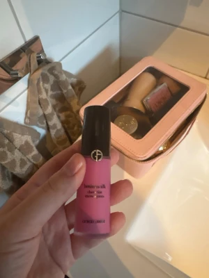 Luminous Silk Cheek Tint från Armani - Flytande rouge i en fräsch rosa nyans från Giorgio Armani. Kommer i en smidig tub med svart lock och elegant logga. Perfekt för att ge kinderna en naturlig glow och enkel att applicera med fingrar eller borste.