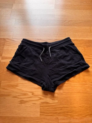 Svarta mjuka shorts med snörning - Svarta mjukis shorts med två fickor på framsidan 