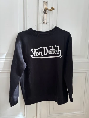 Sweatshirt från Von Dutch - Svart sweatshirt från Von Dutch med vitt logotryck på bröstet.  