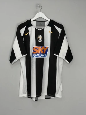 Juventus matchtröja svartvit Nike - Juventus fotbollströja i svartvitt med klassiska ränder, Nike-logga och klubbmärke på bröstet. Två stjärnor ovanför loggan och stor SKY Sport-sponsor på magen. Perfekt för dig som älskar fotboll och vill visa ditt stöd för laget.